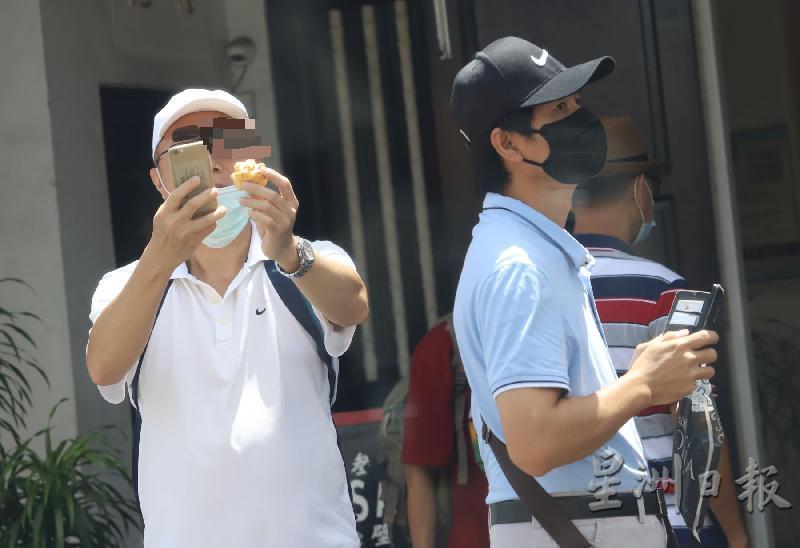 游客拉下口罩在街边拍摄手中食物，也算违法。