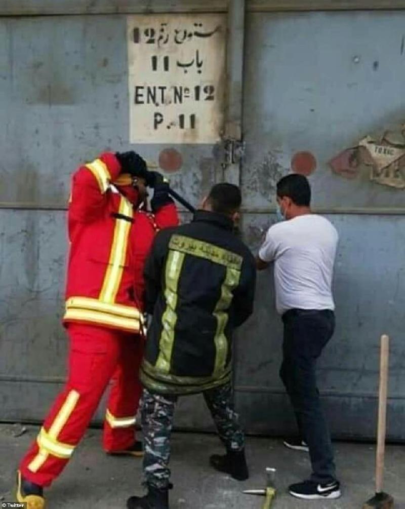 三名消防员试图打开仓库大门。