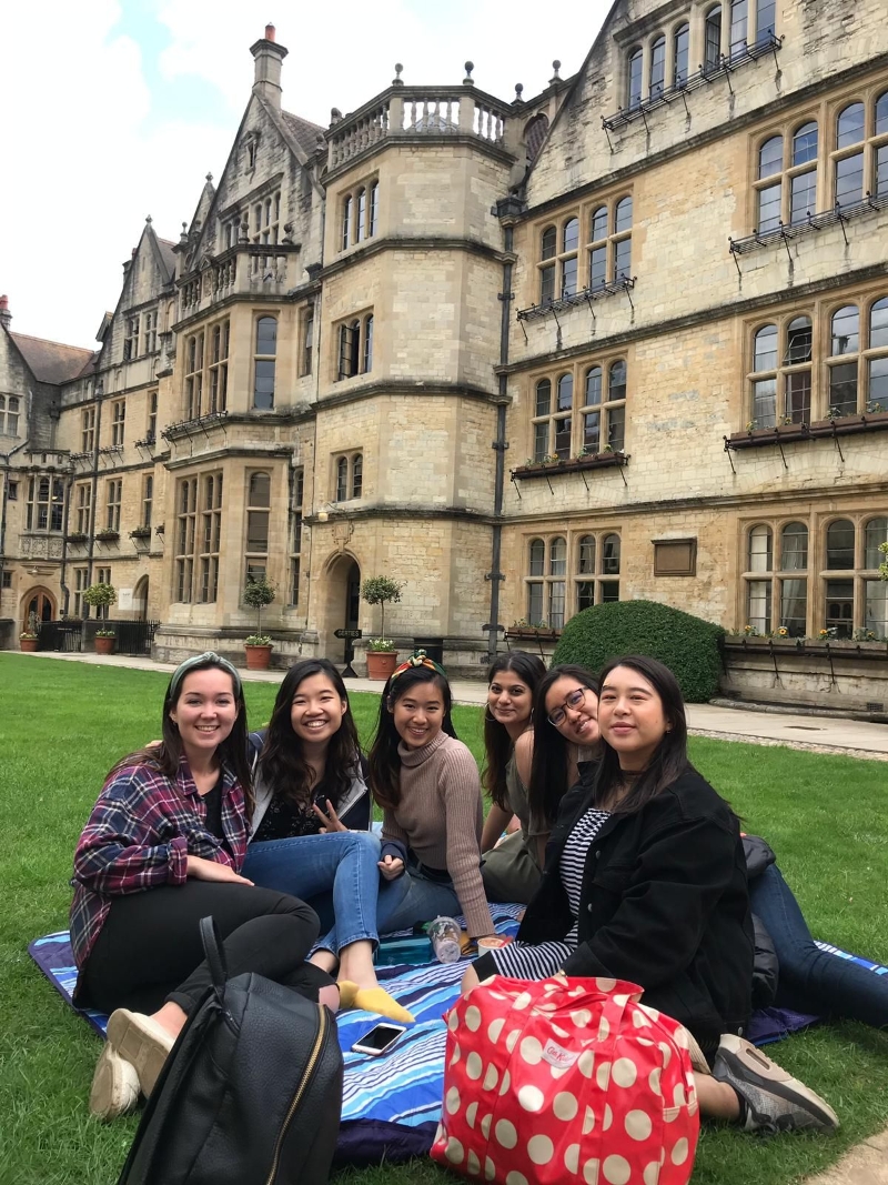 黄明仪（右二）在牛津大学校园的草地上与同学们享受阳光，右三为杰丝丽娜。