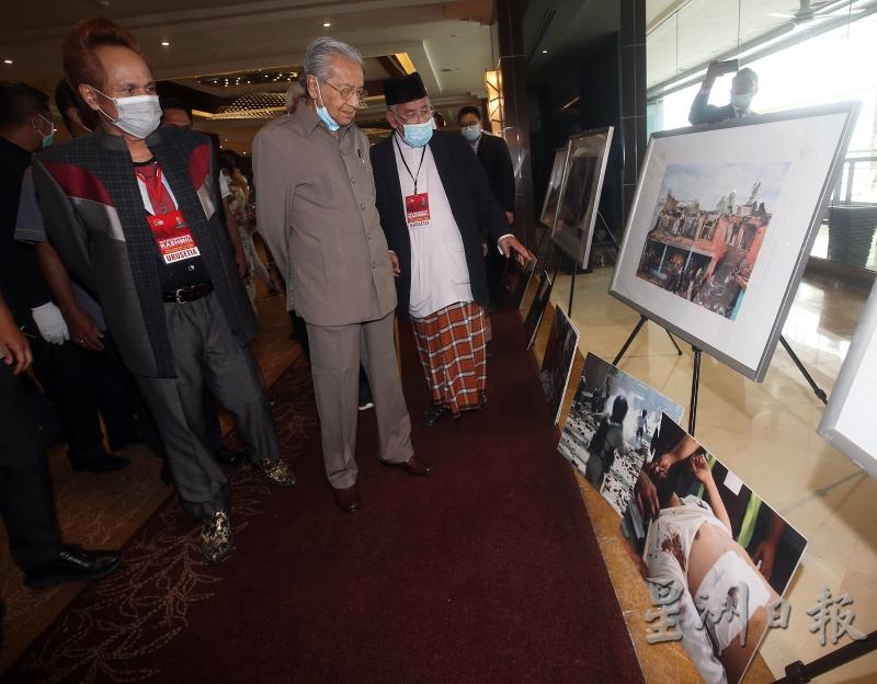 马哈迪（中）出席“与喀什米尔同在”活动时观看展出的照片，右为大马伊斯兰组织咨询理事会主席莫哈末阿兹米。