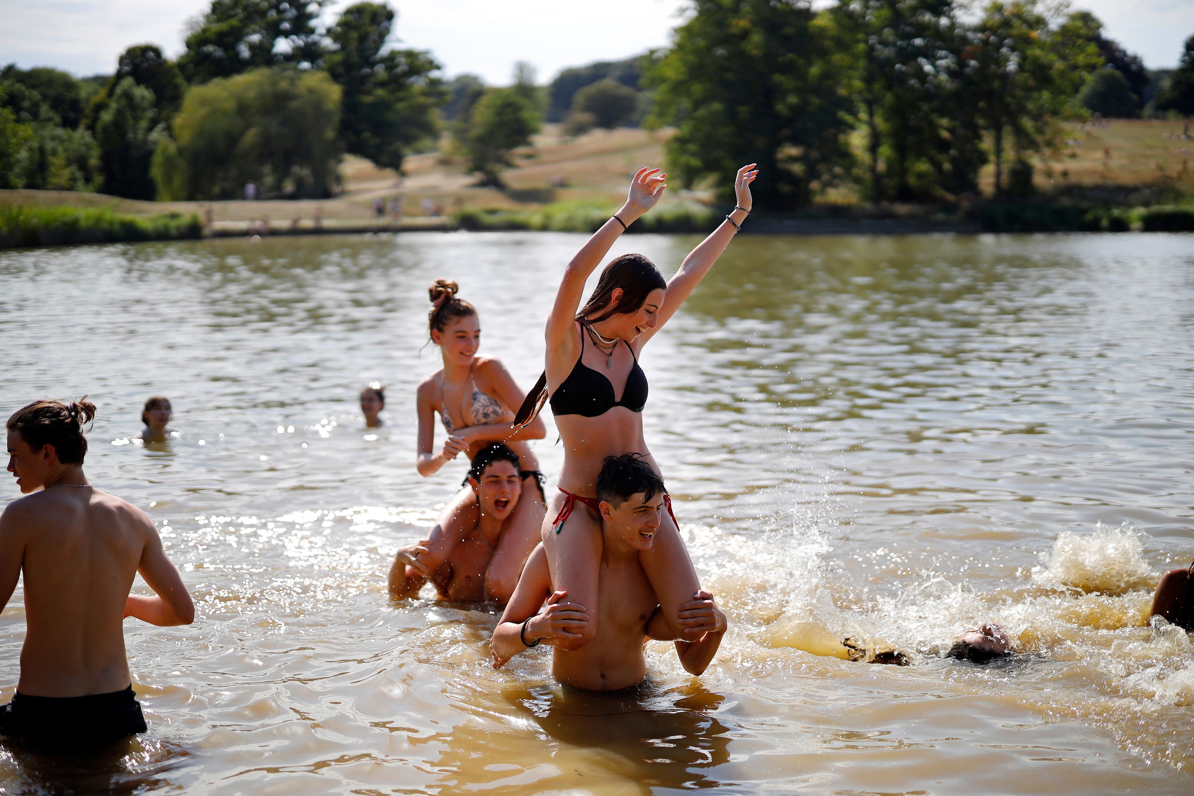 伦敦的气温飙升，让不少青年男女换上泳装，到凉爽的湖水中寻求一丝凉意。(法新社图片)