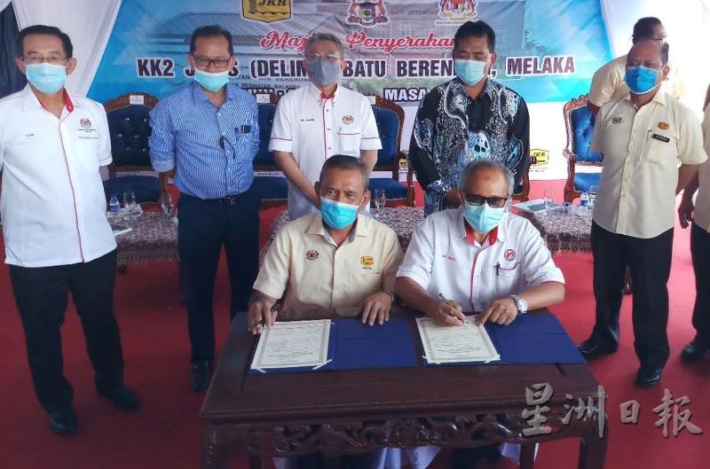 甲工程局局长依斯迈（左）与甲卫生局局长依斯迈阿里（右）签署移交备忘录。后排左起陈超明、罗斯兰、阿汉峇峇、拉末马利曼及拉兹万。