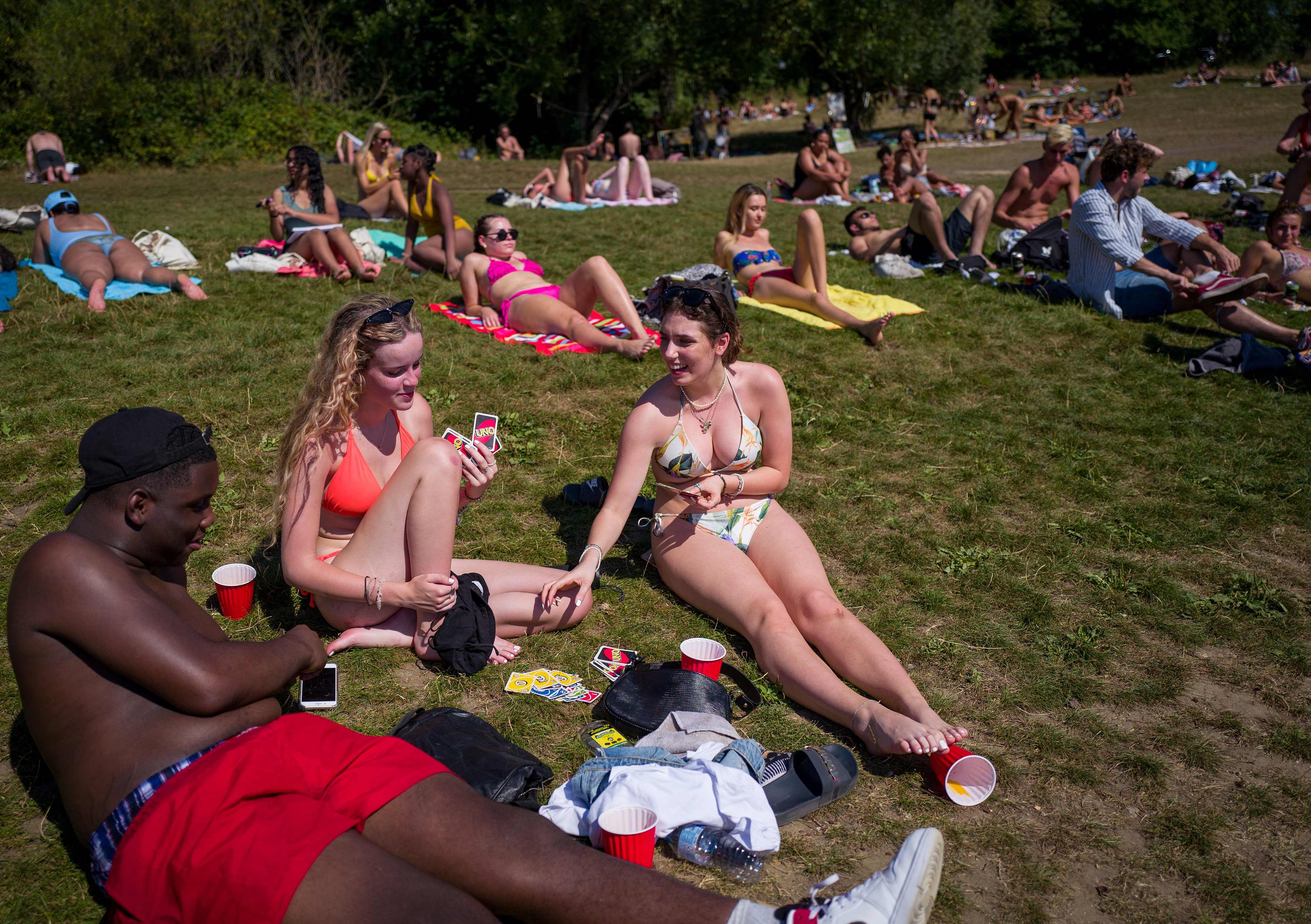 在伦敦市郊，换上泳装的民众们在池塘边享受着日光浴。(法新社图片)