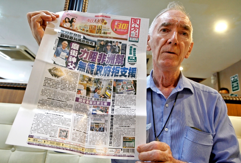 胡颂恒神父向记者展示香港报章有关其反毒事迹的报道，并希望本地媒体能大肆报道以唤起社会大众对毒骡事件的警觉意识。

