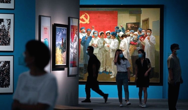 Among the large canvases on display, a painting shows an ecstatic nurse reading a letter from President Xi to her colleagues. AFP