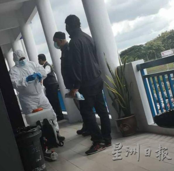 卫生部人员在瓜拉姆拉警区总部内外消毒。