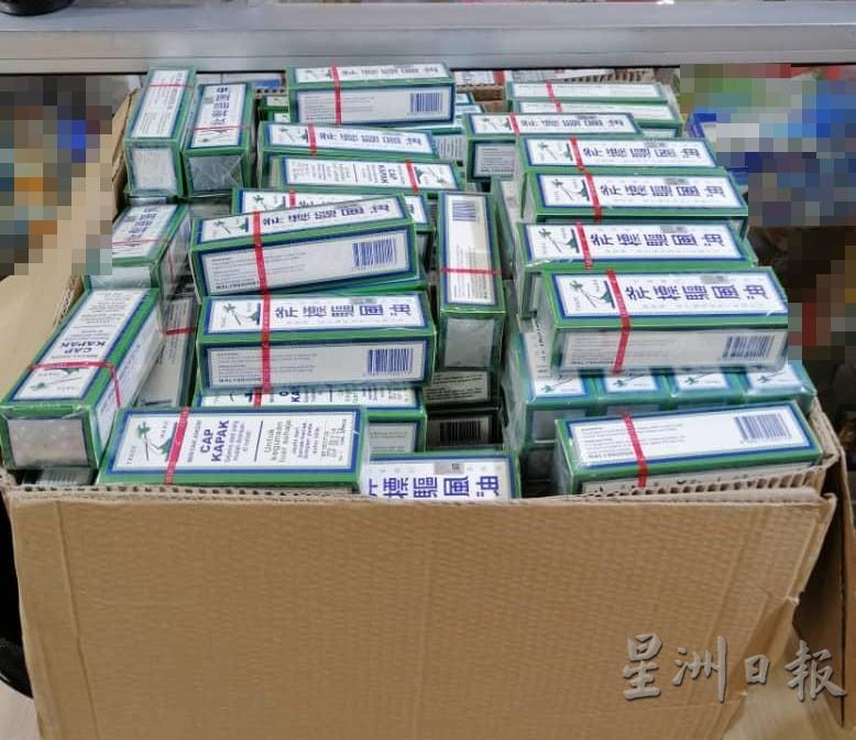 贸消局执法官员充公多瓶驱风油赝品。(图由甲贸消局提供)