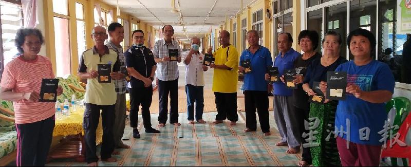 峇都达瑙区州议员保罗斯贡邦（左六）分发肯雅兰金卡给长屋乐龄人后合影。