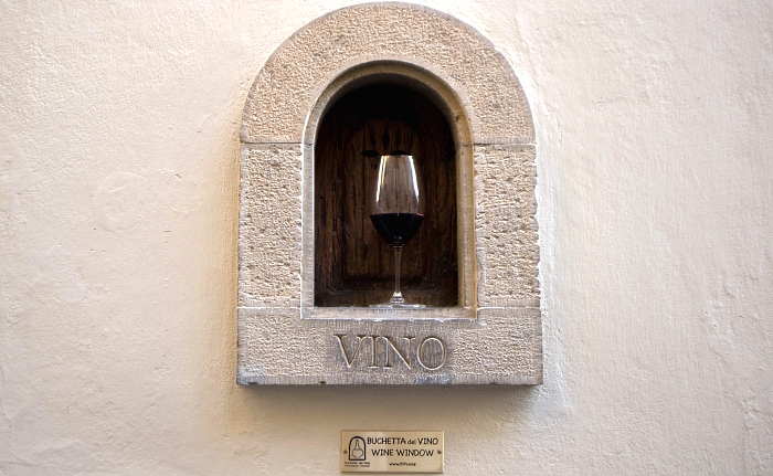 A glass of wine is displayed in the ""buchetta del vino", a small window to serve wine, a tradition which has been in existence since the Renaissance period and is typical in the streets of Florence, Italy. As 16th century Florentines dropped like flies to the plague, survivors drowned their fears in wine passed to them through small windows which are enjoying a renaissance during the current coronavirus pandemic. The small "wine windows" can be seen dotted across the Tuscan capital next to grand entrances of sumptuous noble palaces where wealthy families used to sell alcohol directly to thirsty customers, passing flasks through to eager hands. AFP