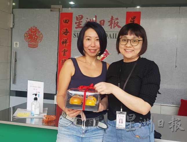 Macaron Seduction的邓丽清（左）是中秋佳节送礼活动的合作伙伴之一，为本报提供美味的上海月饼。右为本报市场兼学生阅报计划高级执行员潘静雯。
