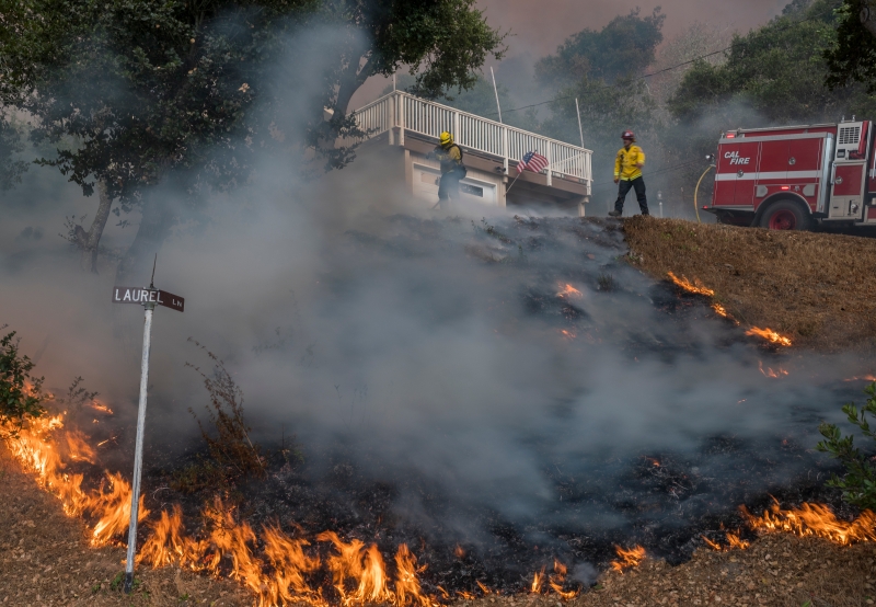 加州林业与消防局的消防员致力于拯救加利福尼亚萨利纳斯附近河边的房屋 。（美联社照片）