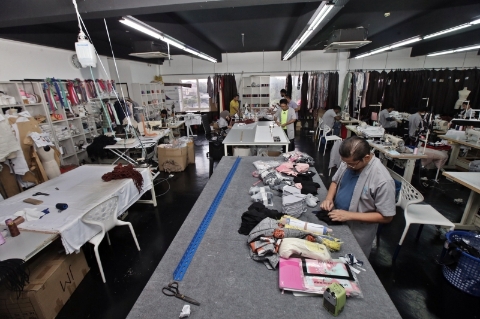 由于消费者对于时装的需求下降，他的工作室目前投入于生产布质口罩。