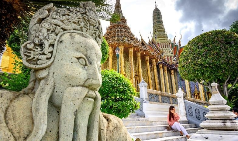 A tourist poses for a photo inside the Grand Palace in Bangkok as it reopened for visitors. AFP A tourist poses for a photo inside the Grand Palace in Bangkok as it reopened for visitors. AFP