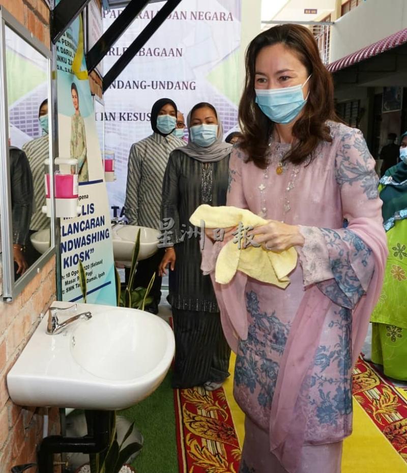端姑莎拉在霹雳州务大臣夫人拿汀斯里诺米（中）的陪同下亲自到洗手盆前洗手，为洗手台主持开幕。
