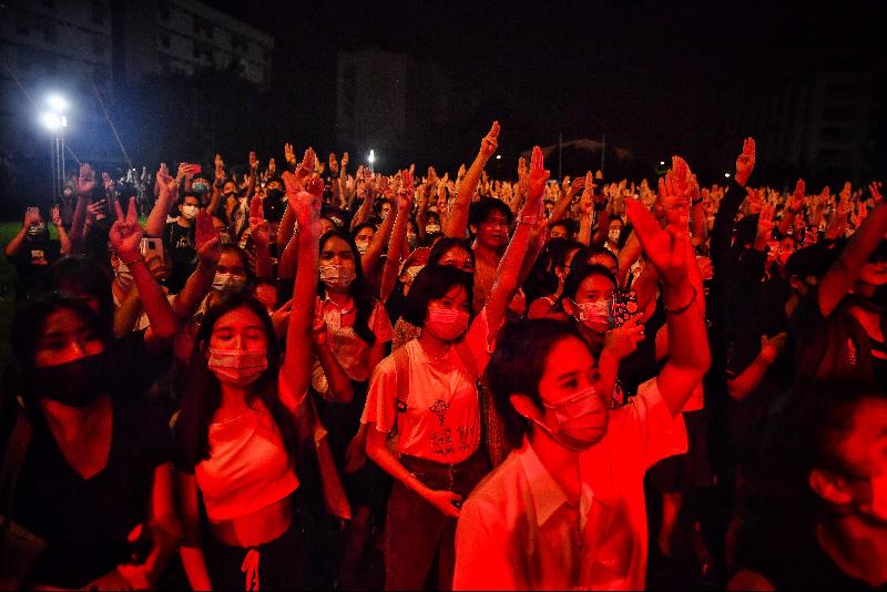 泰国示威者一手举电影《饥饿游戏》的“3指礼”手势。（图：法新社）