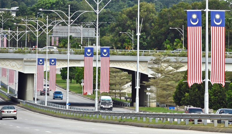 高速公路灯柱上悬挂的国旗，提醒大家国庆月到了。
