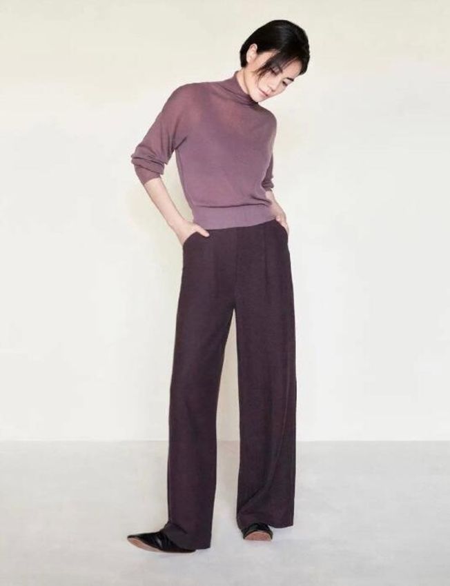 王菲身穿紫色透视高领上衣搭配色阔腿裤，一头利落的短发，搭配清冷的面庞和超酷的表情，看起来气场超强。