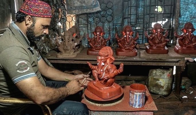 After the pandemic clobbered his pottery business, Yusuf Zakaria Galwani turned to a Hindu god to revive his fortunes by making environmentally friendly Ganesha idols. AFP