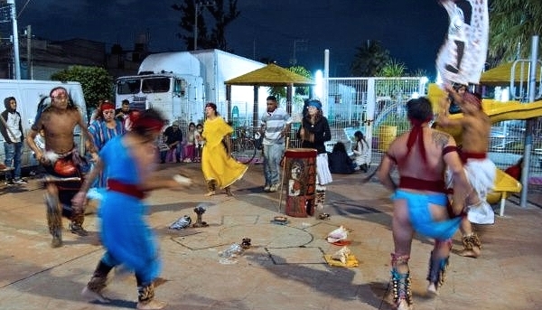Members of Los Cogelones perform an Aztec ritual dance with friends in the streets of Ciudad Nezahualcoyotl. AFP