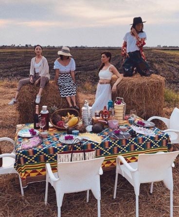 吴俐璇和吴天瑜、王爱玲、Danielle在适耕庄收割后的稻田边野餐，并在卷卷草上拍照，被指拍出美国西部时尚大片的美感。