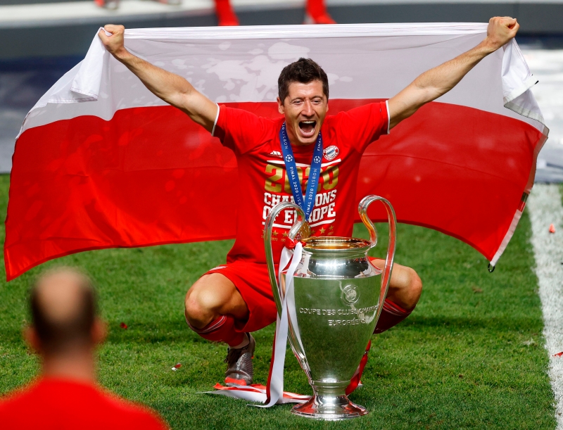 莱万多夫斯基以15球拿下欧冠金靴奖，他能否在今年被评选为世界足球先生？图为莱万高举波兰国旗与欧冠奖杯合照。（法新社照片）
