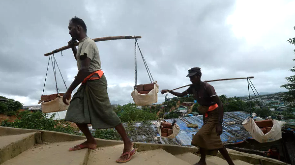 Rohingya men carry bricks for construction work in Jamtoli refugee camp near Ukhia. AFP