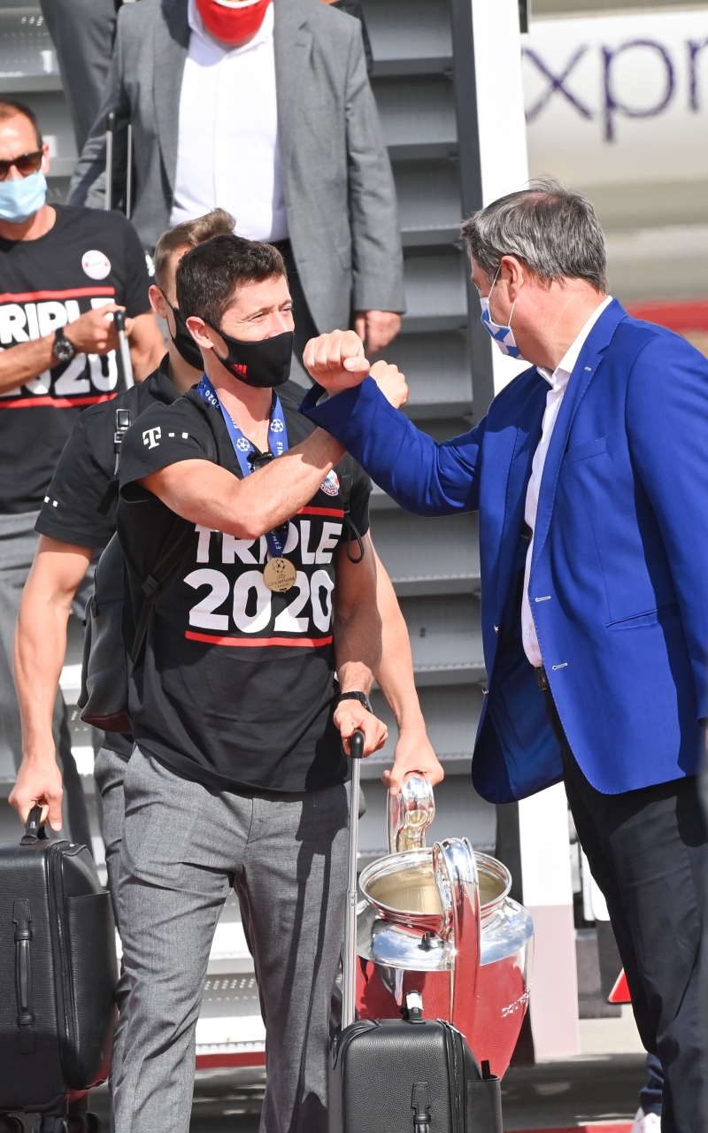 巴伐利亚邦总理索德在慕尼黑机场迎接称霸欧冠的拜仁慕尼黑，最先与持杯的前锋莱万多夫斯基打招呼。（法新社照片）

