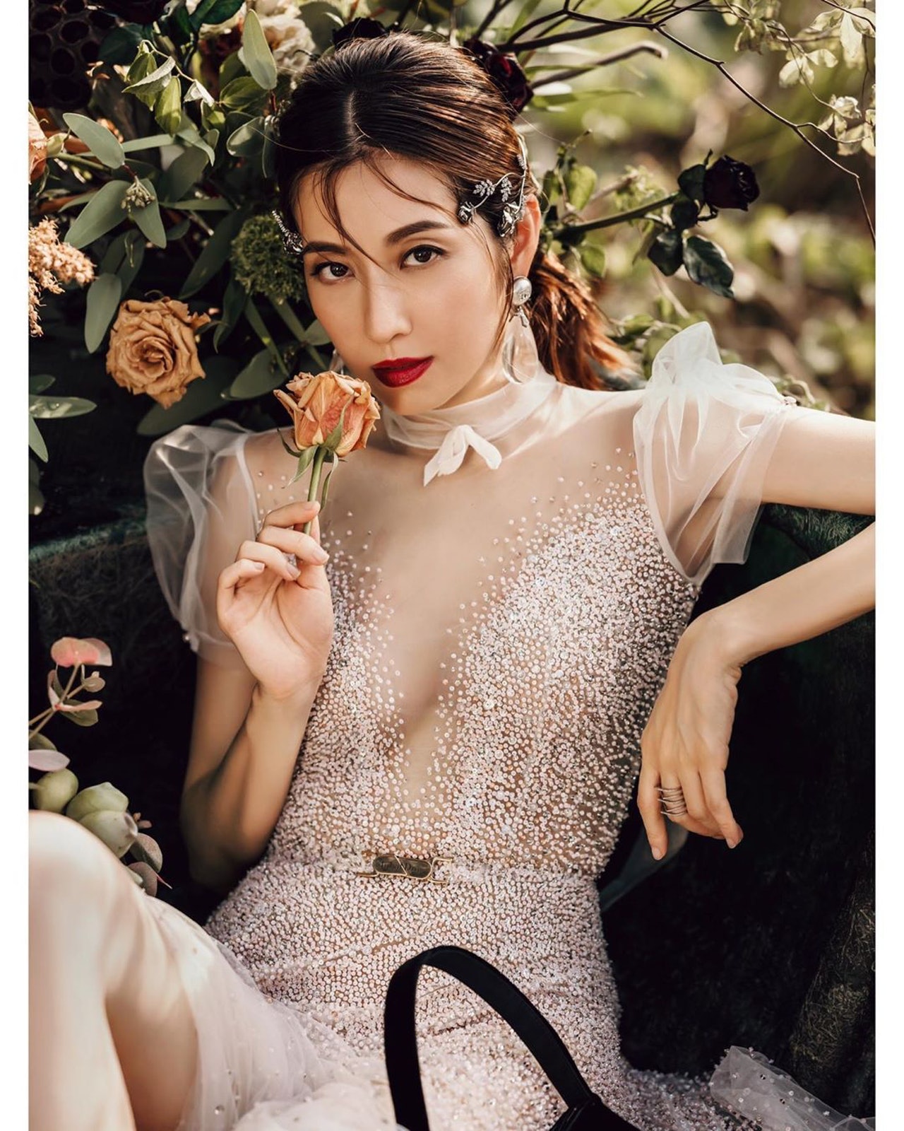 其中一张婚纱照中，陈自瑶手执鲜花，深情凝视镜头，非常优雅。