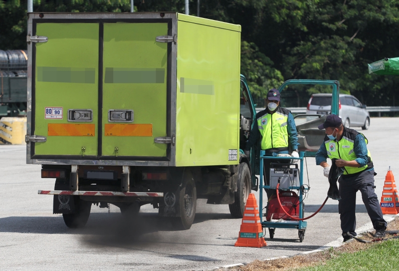 霹雳州环境局官员逐一检查罗里的排碳量。