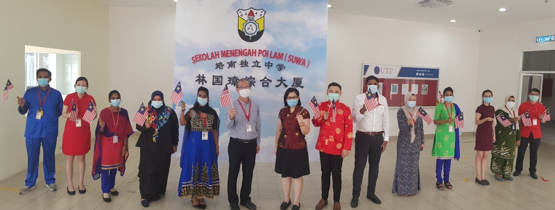 梁炳初（左六起）、行政副校长林柔清以及穿着民族服装的各族老师合照，以此表达该校坚持多元包容的原则。