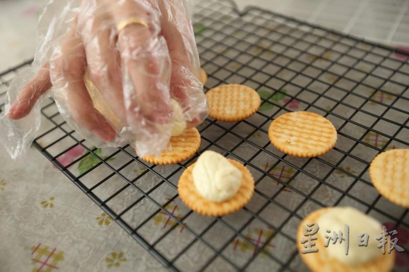 在煮好牛轧糖内陷后，直接搓成球状放在饼乾上，无需放入冰箱。