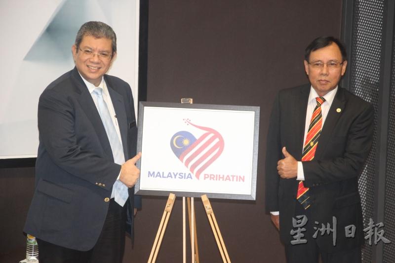 通讯及多媒体部长赛富丁阿都拉（左）推展今年831国庆日及916马来西亚日主题与标志。右为砂公用事业部长史蒂芬伦迪。