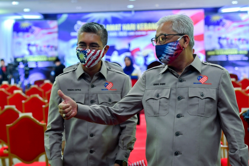 国防部高级部长拿督斯里依斯迈沙比利（右）和财政部长拿督斯里东姑赛夫鲁戴上具马来西亚特色的口罩，在活动庆典中交谈。