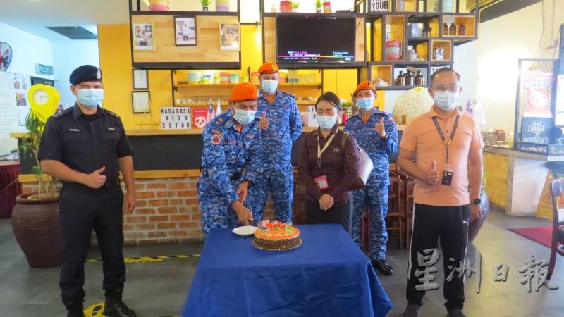 不能大游行也要小庆祝，阿旺阿斯甘达（左二）切国庆蛋糕。