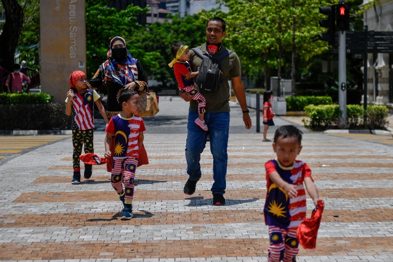 吉隆坡一巫裔家庭一家大小在国庆日当天，身穿印有国旗的衣服出游，想通过服饰传递对国家的爱戴。（马新社照片）