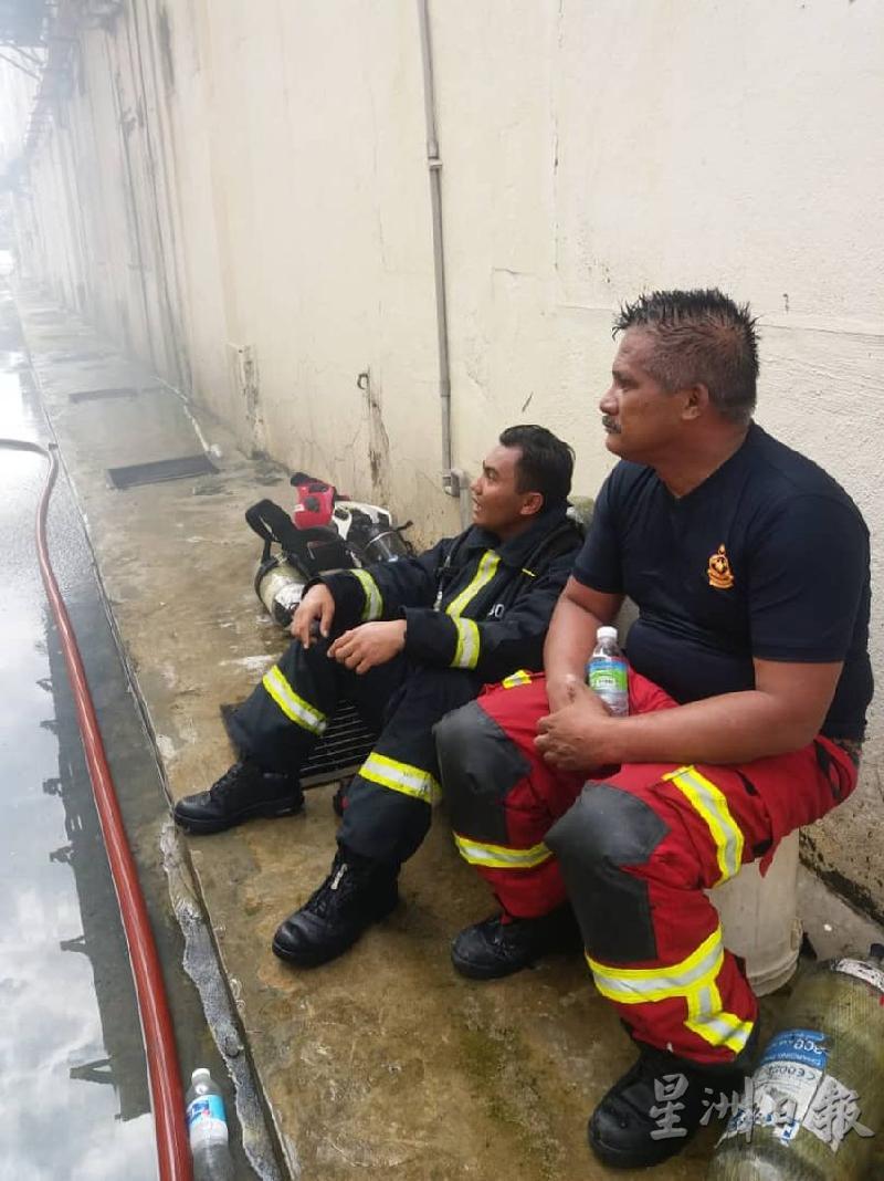 消拯员在控制火势后，精疲力竭在旁休息。