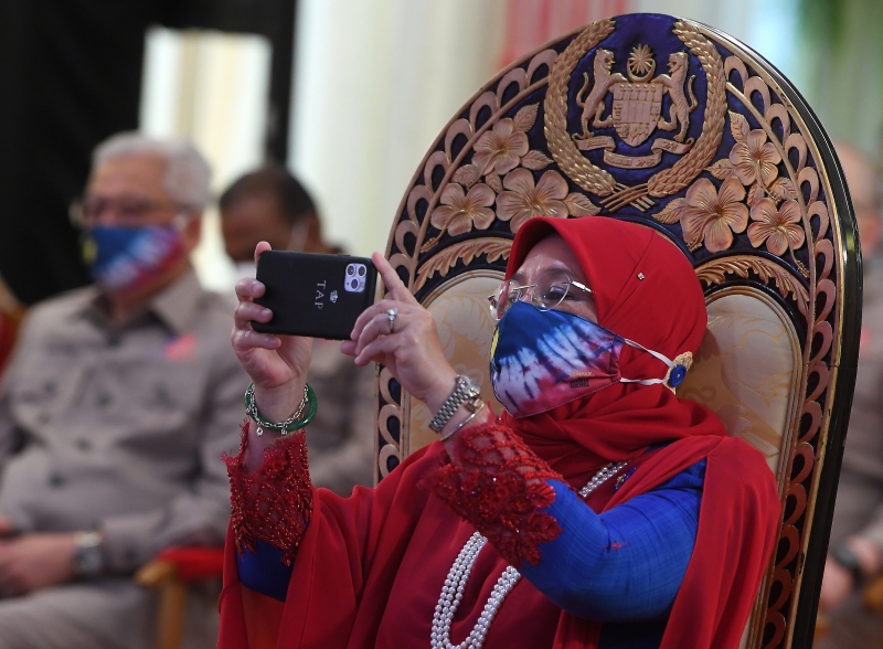 国家元首后东姑阿兹莎阿米娜在国庆日庆典活动上拿起手机拍照。