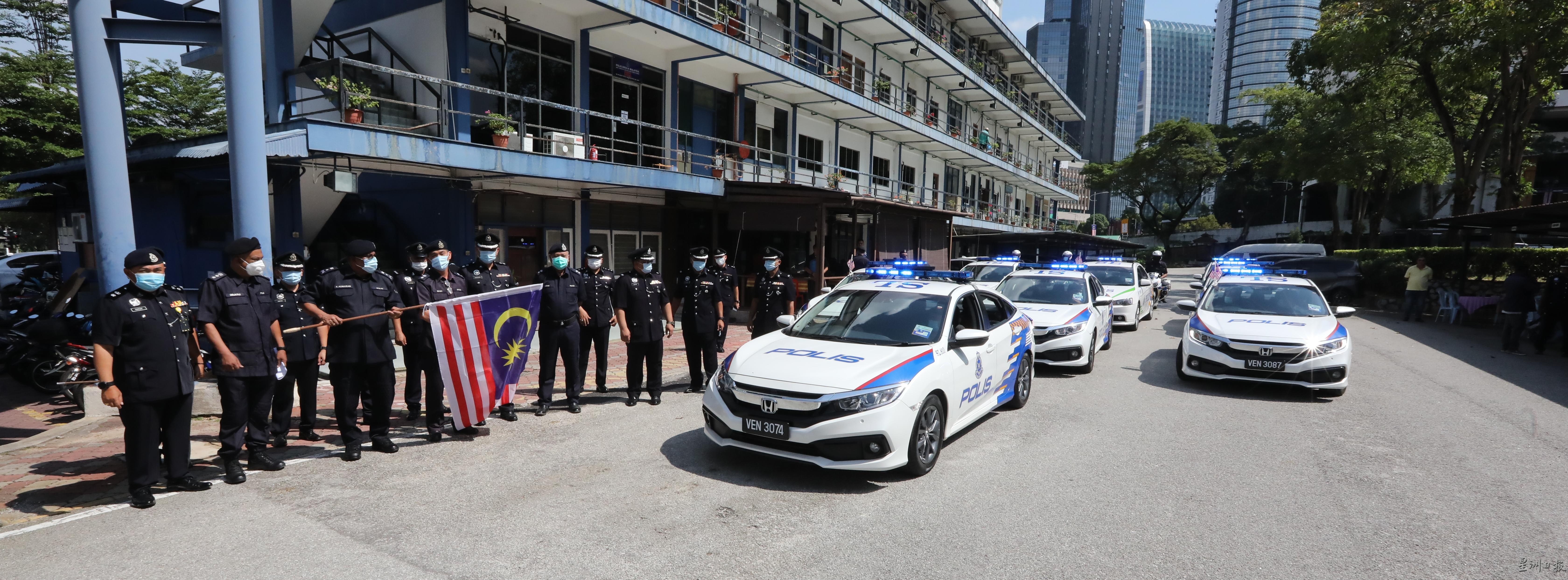 手握国旗的古马兰及各警区主任或副主任一起主持大型巡逻推介仪式。

