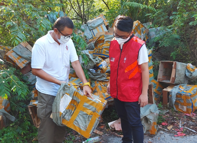 刘佳达（左）及丘钦瀚检查丢弃路边的空运包裹箱子，住址是全国各地。