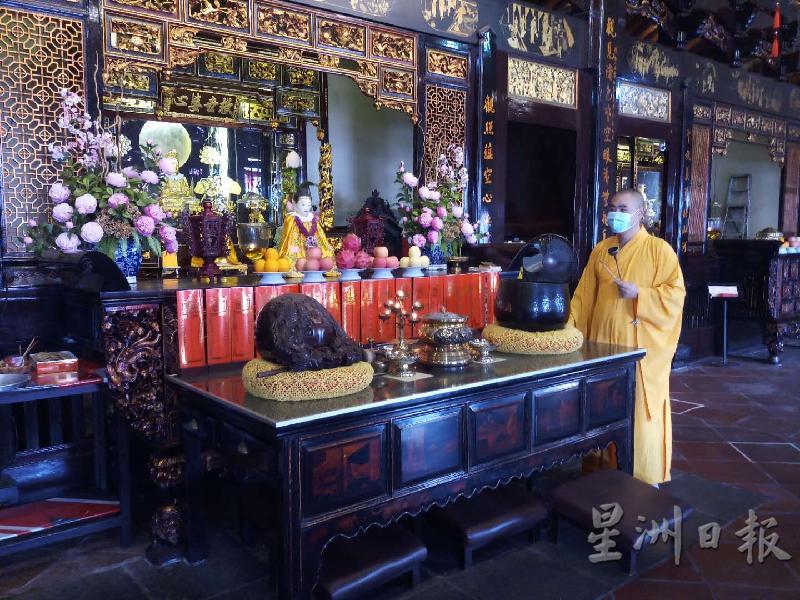 法界师父在佛殿内诵经。