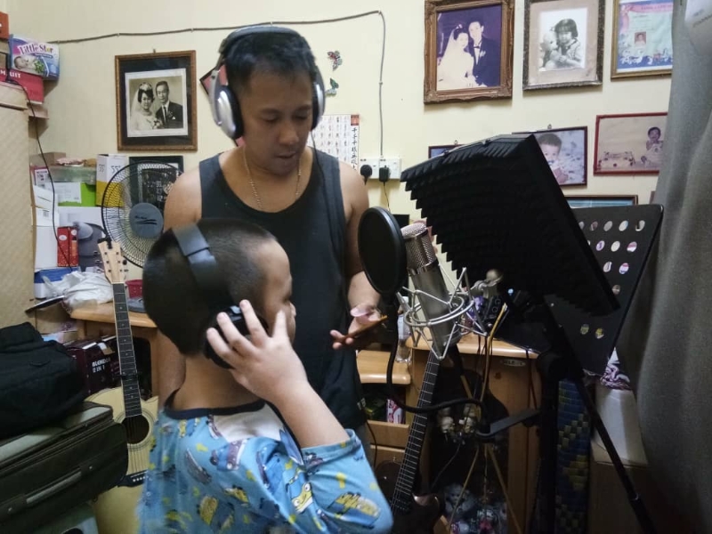 歌手刘纹全（右）指导童声骆恺录音。
