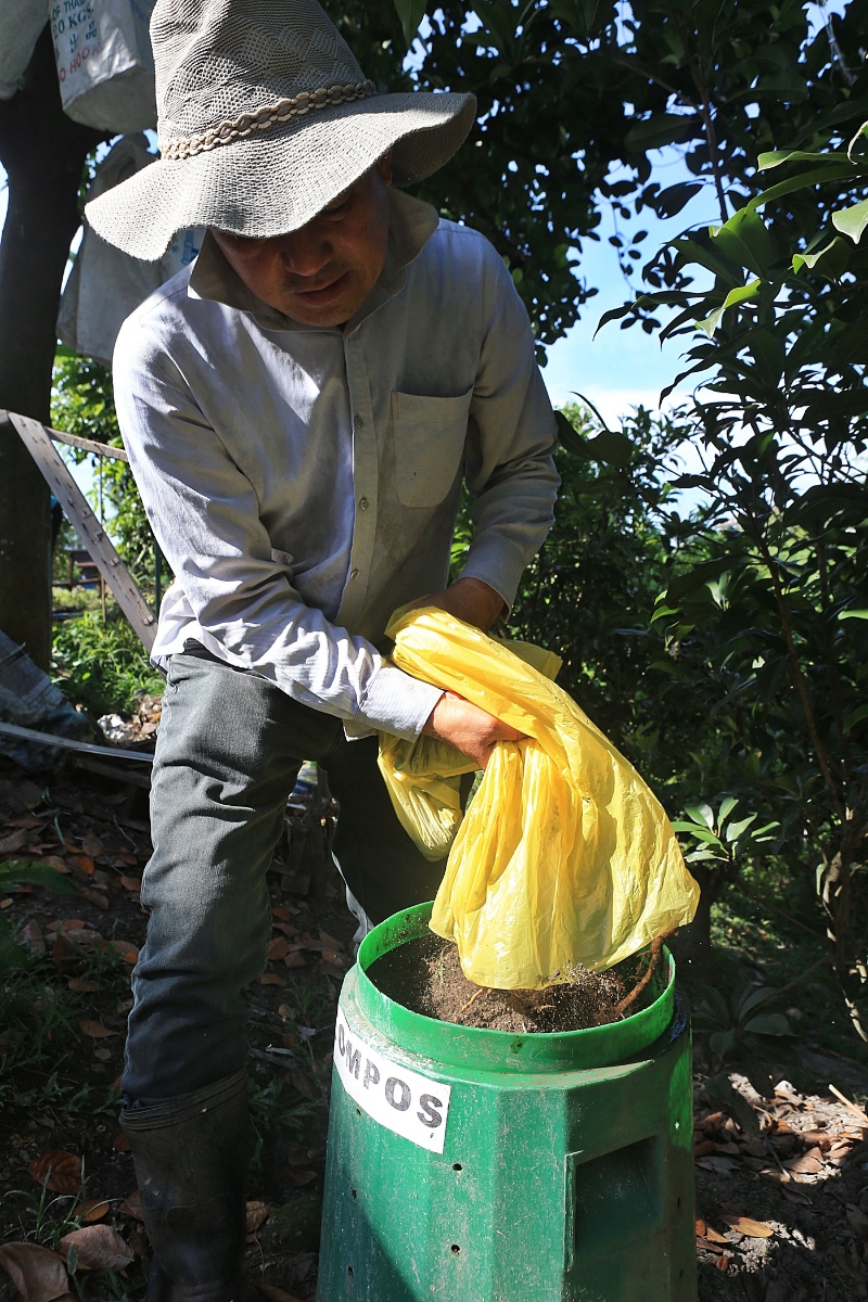 陈时明把收集回来的沙土和咖啡渣放进堆肥桶。
