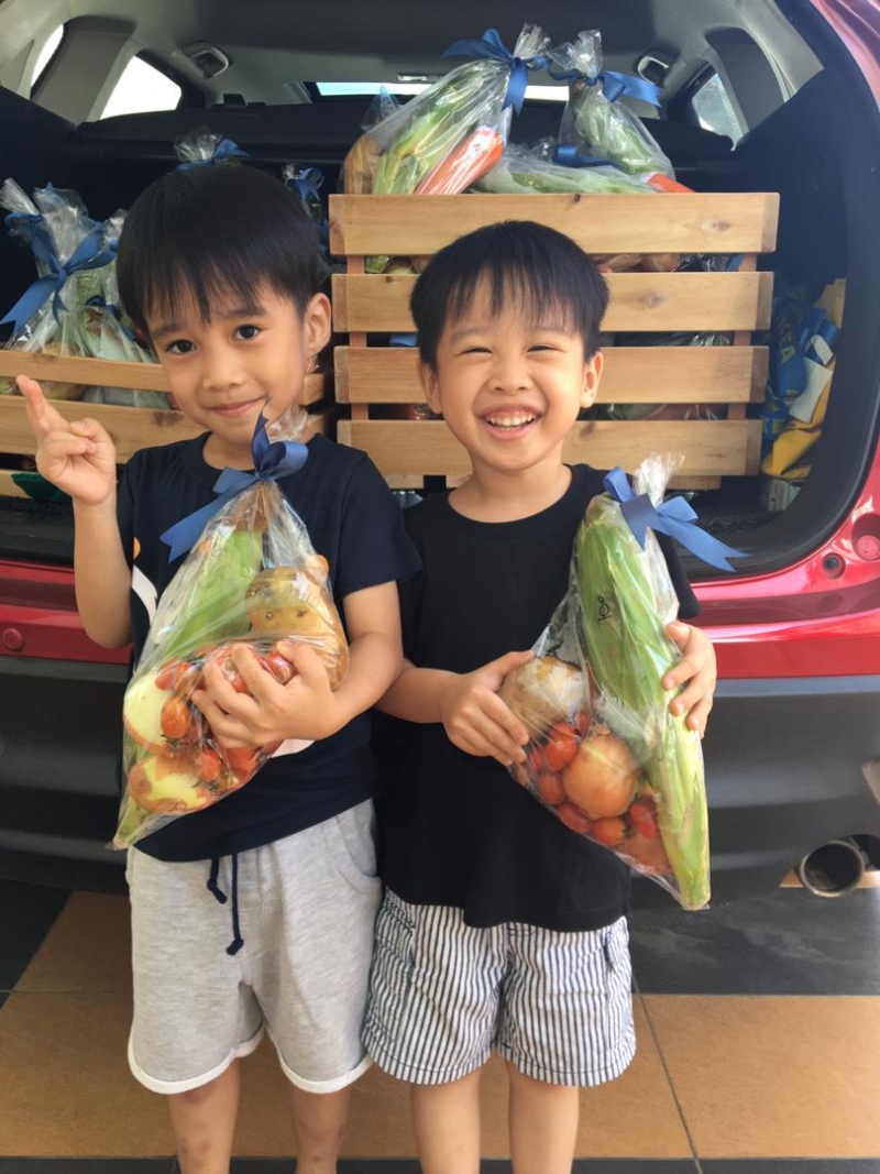 5岁的双胞胎兄弟，即哥哥陈佳辉（右）和弟弟陈佳勇展示他们用庆生红包钱购买的蔬菜包，准备捐到美里医院儿童病房。