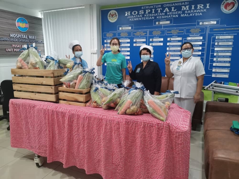 张晓勤（左二）代表儿子移交蔬菜包给美里医院。