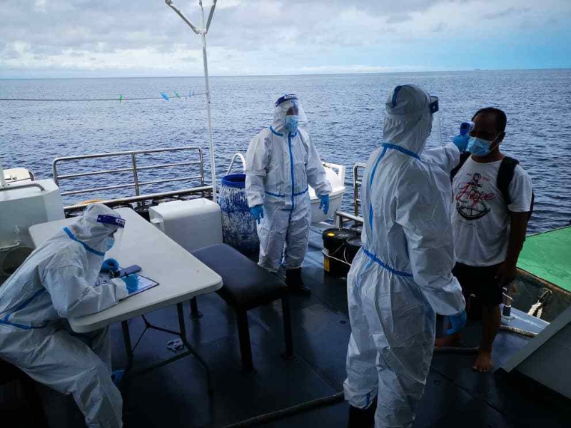 卫生部官员为船员进行冠病检验。