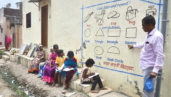 Every day, small groups of students voluntarily gather at the painted walls in Nilamnagar village for their outdoor classes. AFP Every day, small groups of students voluntarily gather at the painted walls in Nilamnagar village for their outdoor classes. AFP