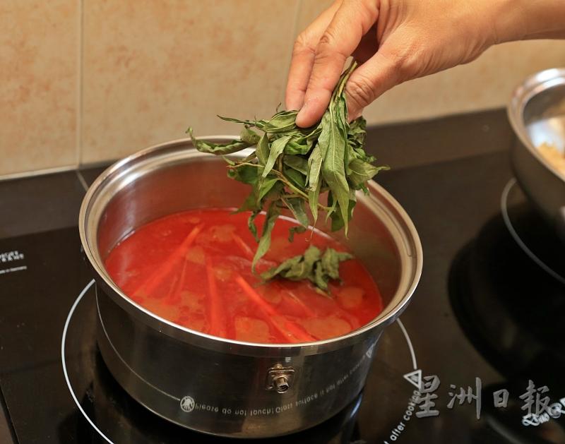 3.依顺序将叻沙叶、羊角豆、番茄及姜花放入锅中熬煮一会儿。