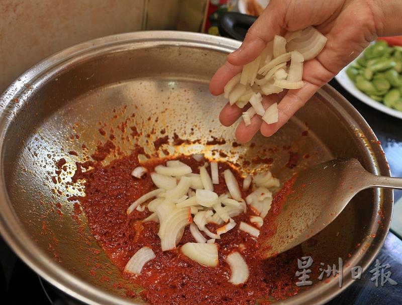 2.倒入辣椒糊炒香后，放入洋葱片。