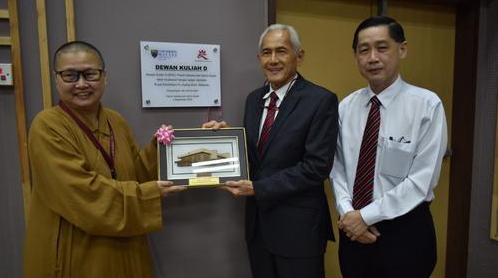 Universiti Malaysia Vice Chancellor Abdul Rahim Hashim (centre) presents a souvenir to Ven Jue Cheng. On the right is Wong Tze Ken, Dean of the Faculty of Arts and Social Sciences. 