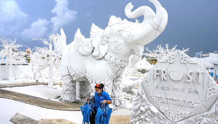 An employee carrying umbrellas among mythical sculptures made of white sand imitating ice in the "Frost Magical Ice of Siam" park outside Pattaya, Thailand. AFP An employee carrying umbrellas among mythical sculptures made of white sand imitating ice in the "Frost Magical Ice of Siam" park outside Pattaya, Thailand. AFP